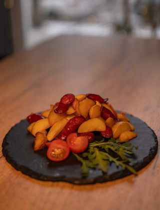 Картопля запечена з ковбасками та беконом, руколою та томатом (300г)