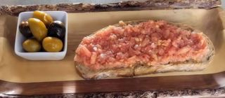 Tostada de pan con tomate y aceite.