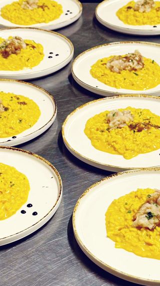 Risotto allo zafferano con tartare di persico e mandorle sgusciate tostate e fondo bruno