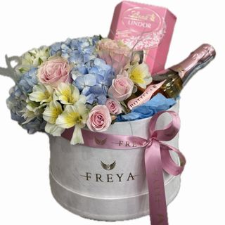 Cutie mică cu flori albastre-roz, spumant și ciocolată