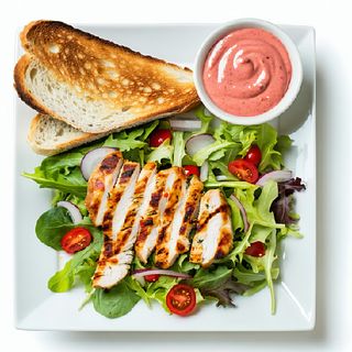 Ensalada de pollo con pan de pizza y salsa rosa a parte