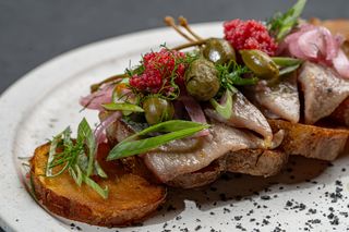 Herring served on a deep fried potato pillow with marinated onion