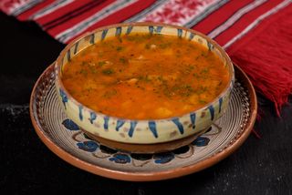 Ciorbă de fasole cu costiţă în pâine şi salată de ceapă roşie