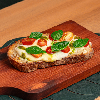 Pao de alho com pesto genovese, tomate confit e caju