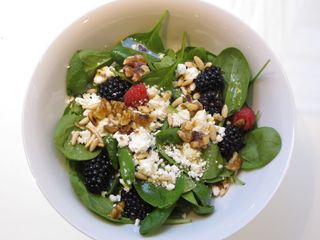 Ensalada de espinacas con queso de cabra, pasas, nueces y frutos rojos