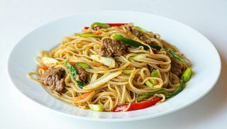 Tăiţei de orez prăjiti cu carne de porc, ou si legume