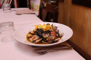 Spaghetti neri con vongole veraci, pesce spada e fiori di zucca