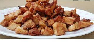 1/2 kg of pork with fat skin ( ekigodo ) dry fried served with pressed matooke, cassava, avocado and kachumbari 