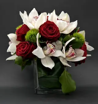 Vetro con rose rosse e orchidee