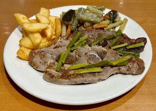 Chuletas de pavo con patatas pimientos y ajos tiernos y guarnición