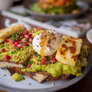 Tostada De Avocado, queso Halloumi, tomate y huevo poached