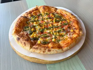 Піца з шинкою, кукудзою, томатами та соусом песто
