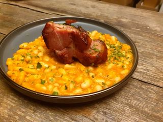 Ciolan de porc servit cu iahnie de fasole