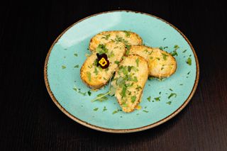 Cartofi copți cu unt, parmezan, usturoi și pătrunjel