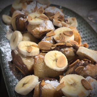 Masa de pizza frita troceada con  nutella y plátano