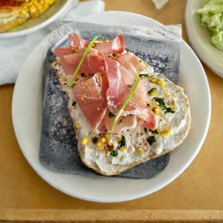 Bruschetta Con jamon serano, queso crema y pistachos picados