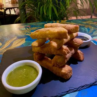 Berenjenas rebozadas en galletas maría con salsa pesto y miel de caña