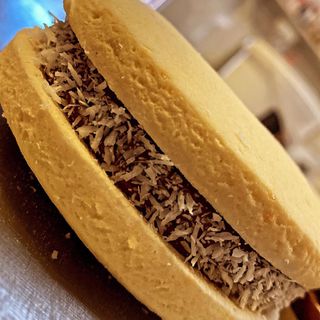 Alfajor de maicena con dulce de leche y coco.