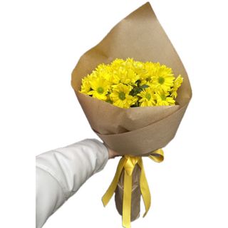Margaridas amarelas embrulhadas em papel kraft