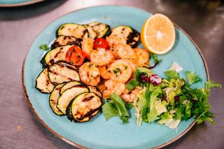 Creveti delicati trasi la tigaie pe pat de zucchini