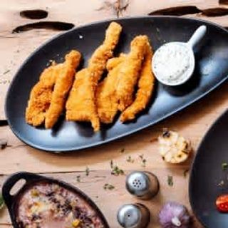 Хрупкави пилешки филенца поднесени с млечно-чеснов сос (250г)