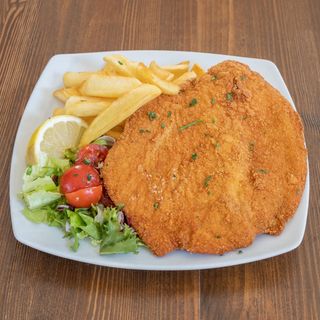 Cotoletta gigante con insalata e patate fritte