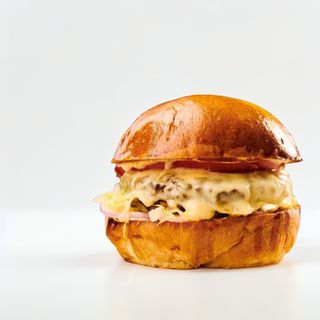 Cheeseburger Însoțit de cartofi și de sosul casei