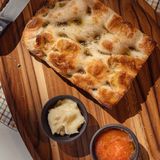 Media focaccia crujiente con hierbas provenzales, tomate y aliol