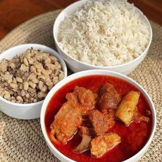White rice and oloyin beans served with shaki, pomo and goatmeat