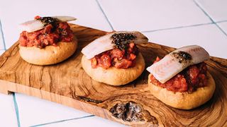 Coca d´oli con titaina, anguila ahumada y pimentas negras