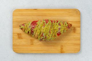Croissant malinowy z polewą pistacjową 110g