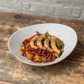 Wok de noodles thai con langostinos y vegetales