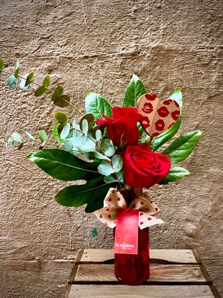 Jarrón de cristal con dos rosas rojas.