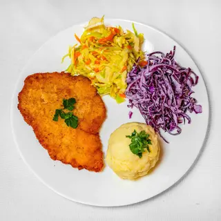 Kotlet schabowy panierowany  z puree ziemniaczanym w towarzystwie surówek