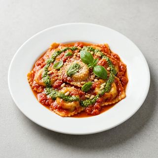 Ravioles de ricota y espinaca en salsa de tomate con pesto de albahaca