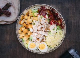 Caesar Deluxe: Salata iceberg, Dressing caesar, piept de pui, crutoane, sos de maioneza, prosciutto crudo