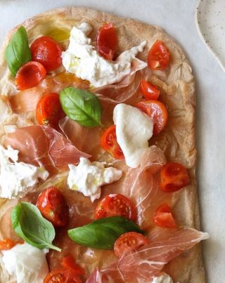 Pinsa con mozzarella fiordilatte, pomodoro fresco, rucola prosciutto crudo