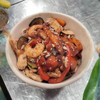 Poke bowl de pollo y langostinos con verduras y salsa kavayaki.