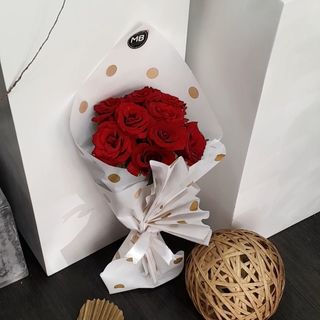 12roses rouges emballage blanc au petit pois. 