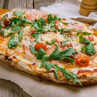 Pinsa con mozzarella fiordilatte, pomodoro fresco, rucola e grana