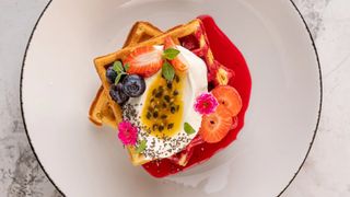 Бельгийские вафли с сырным кремом, ягодами и вишневым соусом