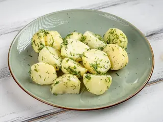 Відварена молода картопля з вершковим маслом, часником та зеленню (250g)