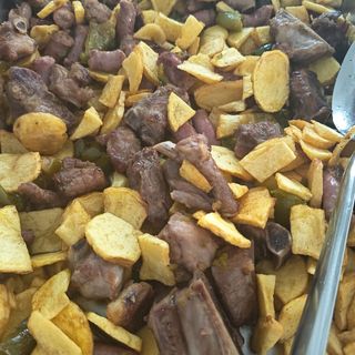 Costillejas, salchichas y pimientos fritos con patata a lo pobre