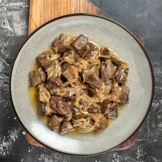 Higados y corazones de pollo encebollados con especias, salsa y acompañamiento a elegir.