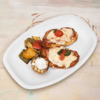Pechuga de pollo a la Parmigiana empanada con mozzarella y tomate