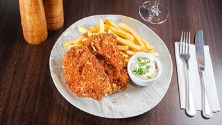 Snitel din cotlet de porc cu parmezan, cartofi prajiti si sos aioli