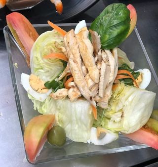 Insalata con hamburger, mais, pomodorini e olive