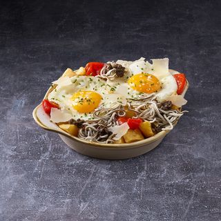 Huevos rotos con gulas y trufa