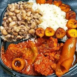 Nigerian beans mixed with white rice served with plantains and assorted
