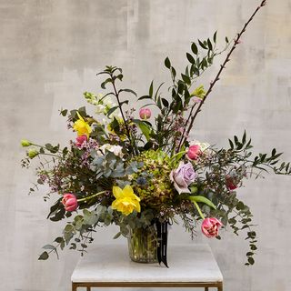 Arreglo de flores de temporada en jarrón de vidrio